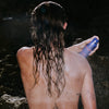 Woman spraying Freaks of Nature Solar Shield SPF 20 Spray (6 oz) on her shoulder