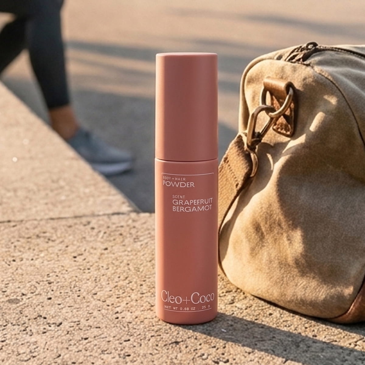 Cleo+Coco Body & Hair Powder - Grapefruit Bergamot (25 g) - on a concrete surface next to a brown bag.