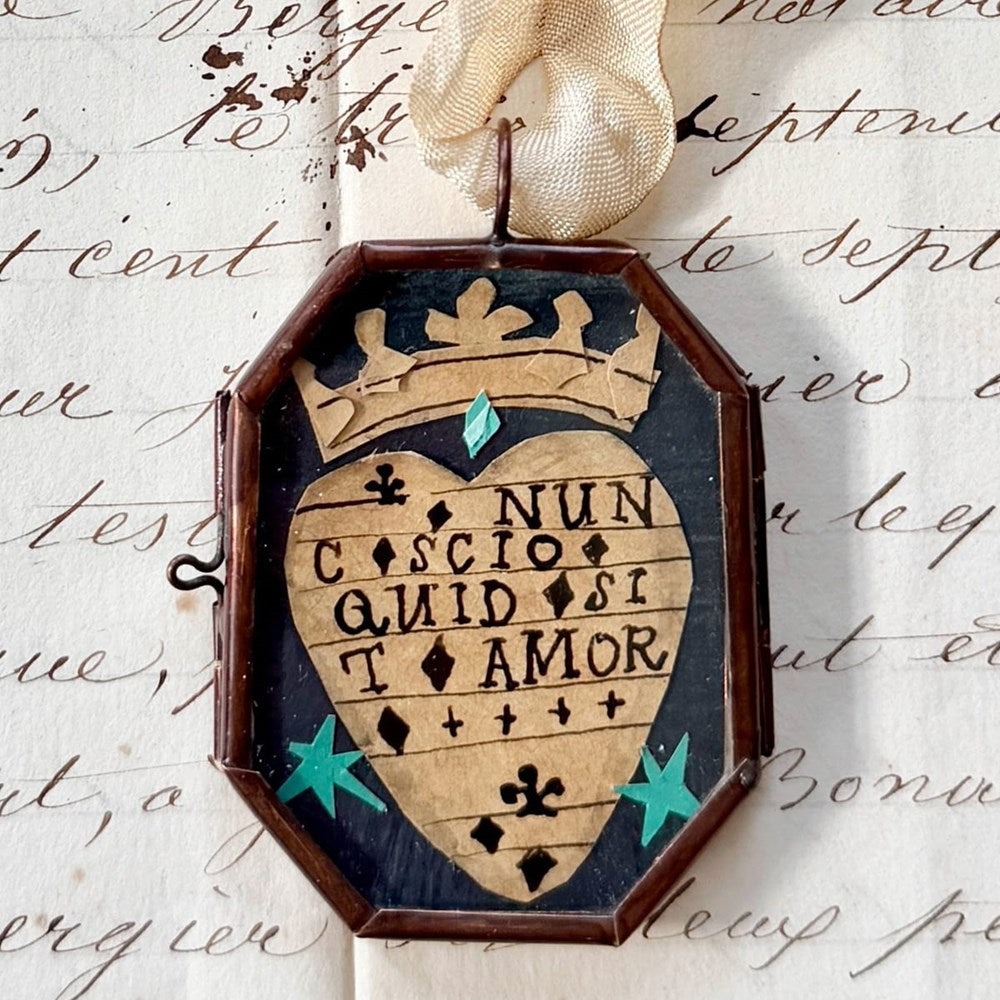 Maris Mirum Small Locket - Nunc Scio Ii. with vintage paper with script handwriting in the background.