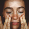 Woman applying Mari St. Lucia Body Oil to face