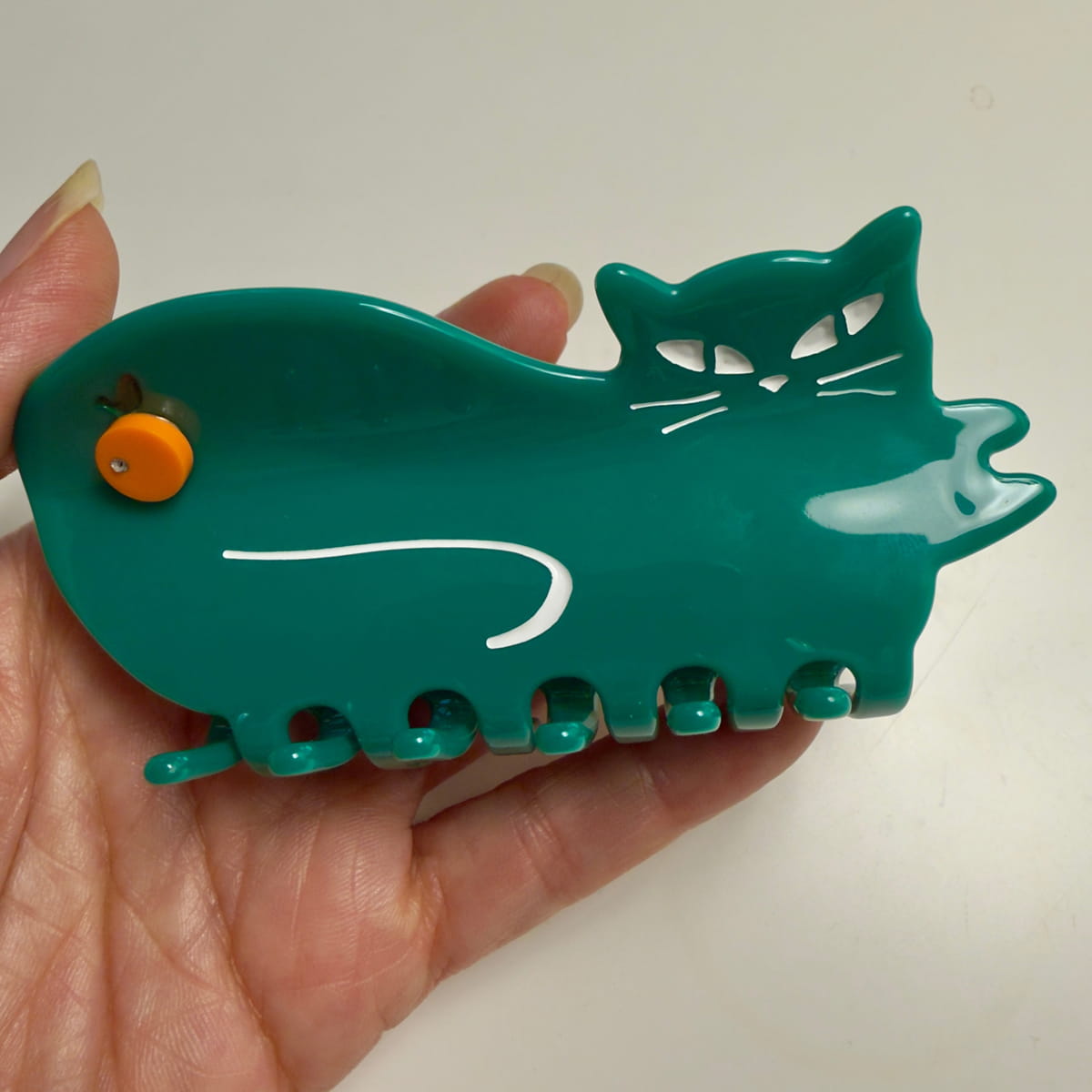 Centinelle Orange Green Cat Hair Claw (1 pc) - product shown being held. 