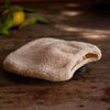La Selva Positano Organic Cotton Makeup Removal Glove (1 pc) - product shown on wooden table.