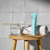 Davids Hydroxi Whitening + Enamel Health Toothpaste – Spearmint (4 oz) - product shown on wooden stool. 