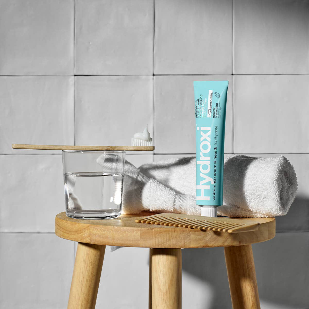 Davids Hydroxi Whitening + Enamel Health Toothpaste – Spearmint (4 oz) - product shown on wooden stool. 