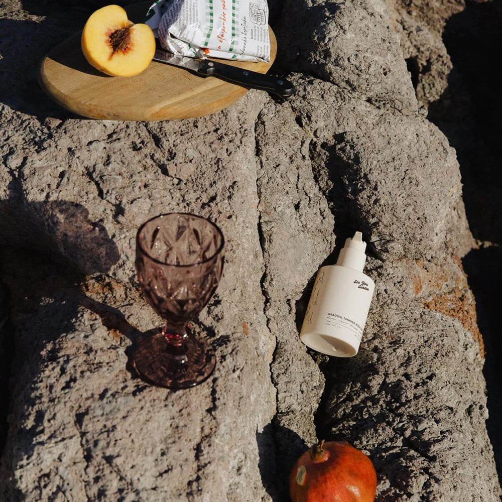 See You Sundae Gradual Tanning Body Butter (300 ml) - product shown on rocks. 