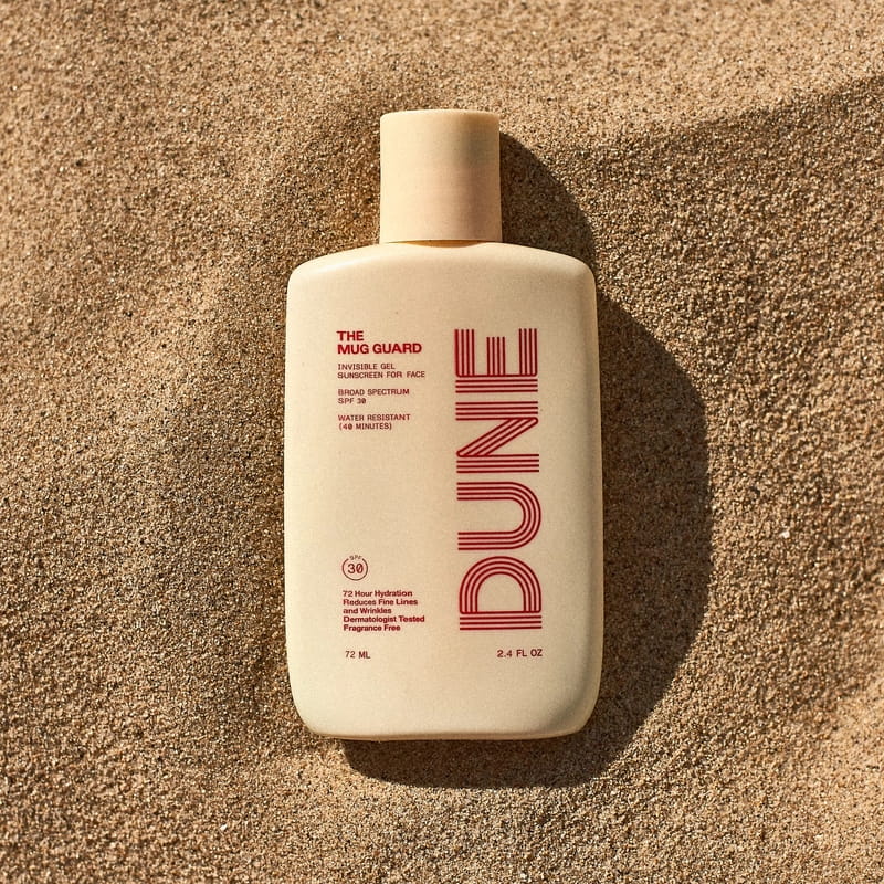 DUNE Suncare The Mug Guard (72 ml) - product shown on sand.