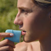 DUNE Suncare The Melt Stick (20.24 g) - product shown being applied to model's lips. 