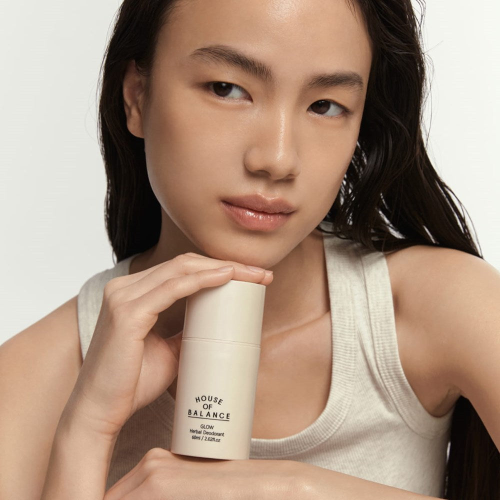 House of Balance Glow Herbal Deodorant (60 ml) - product shown being held by model. 