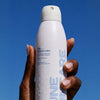 DUNE Suncare The Sporto Spray (148 ml) -  against a clear blue sky.