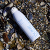 DUNE Suncare The Sporto Spray (148 ml) - product shown on top of shells.