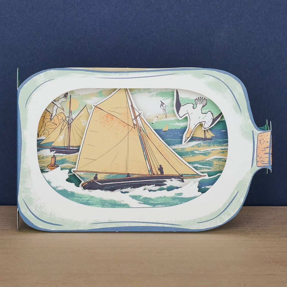Art Angels Sailboat In A Bottle Die Cut Card (1 pc) - product shown on counter.