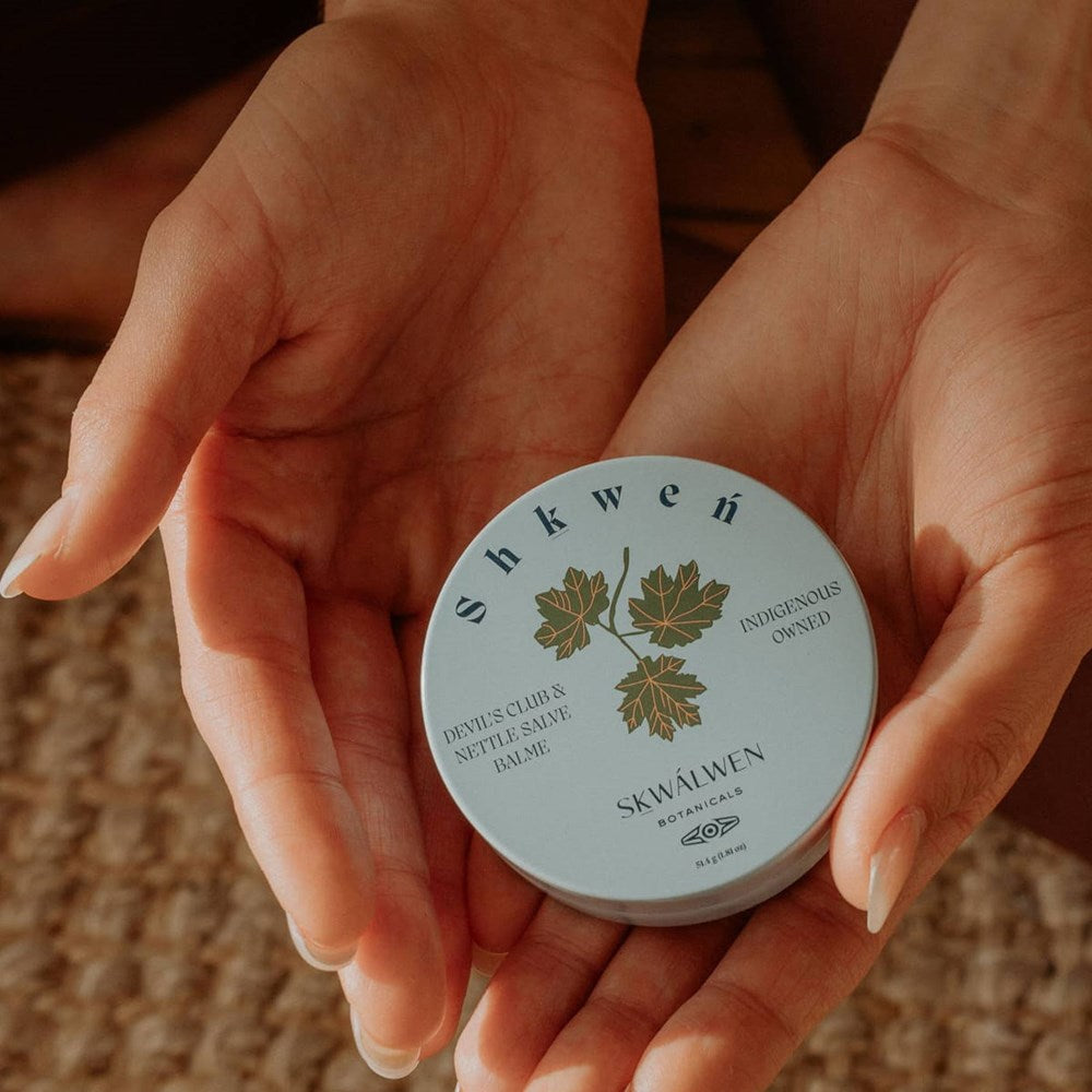 Sḵwálwen Botanicals Shkweń Devil's Club &amp; Nettle Salve (1.81 oz) - product shown being held in hands.