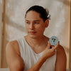 Sḵwálwen Botanicals Shkweń Devil's Club & Nettle Salve (1.81 oz) - product shown being held by model. 