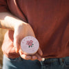 Sḵwálwen Botanicals Kalkáy Wild Rose & Yarrow Salve (1.81 oz) - product shown being held. 