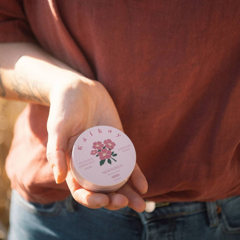 Sḵwálwen Botanicals Kalkáy Wild Rose & Yarrow Salve (1.81 oz) - product shown being held. 