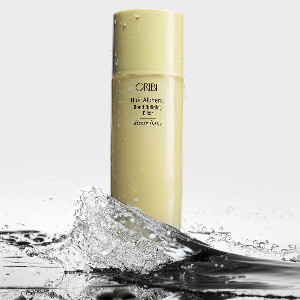 Oribe Hair Alchemy Bond Building Elixir (3.4 oz) - product shown wet in a puddle.
