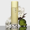 Oribe Hair Alchemy Bond Building Elixir (3.4 oz) - product shown with flowers and fruit. 