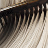 Oribe Hair Alchemy Bond Building Elixir (3.4 oz) - hair shown close up with an Oribe comb.