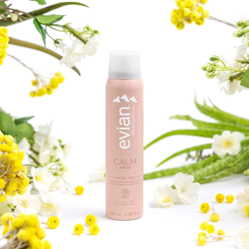 Evian Calm Facial Mist (100 ml) - product shown surrounded by flowers.