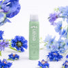 Evian Protect Facial Mist (100 ml) - product shown being surrounded by flowers.