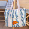 Talking Tables Recycled Plastic Croissant Tote Bag (1 pc) - product shown hanging from chair.
