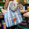 Talking Tables Recycled Plastic Croissant Tote Bag (1 pc) - product shown on women's shoulder.