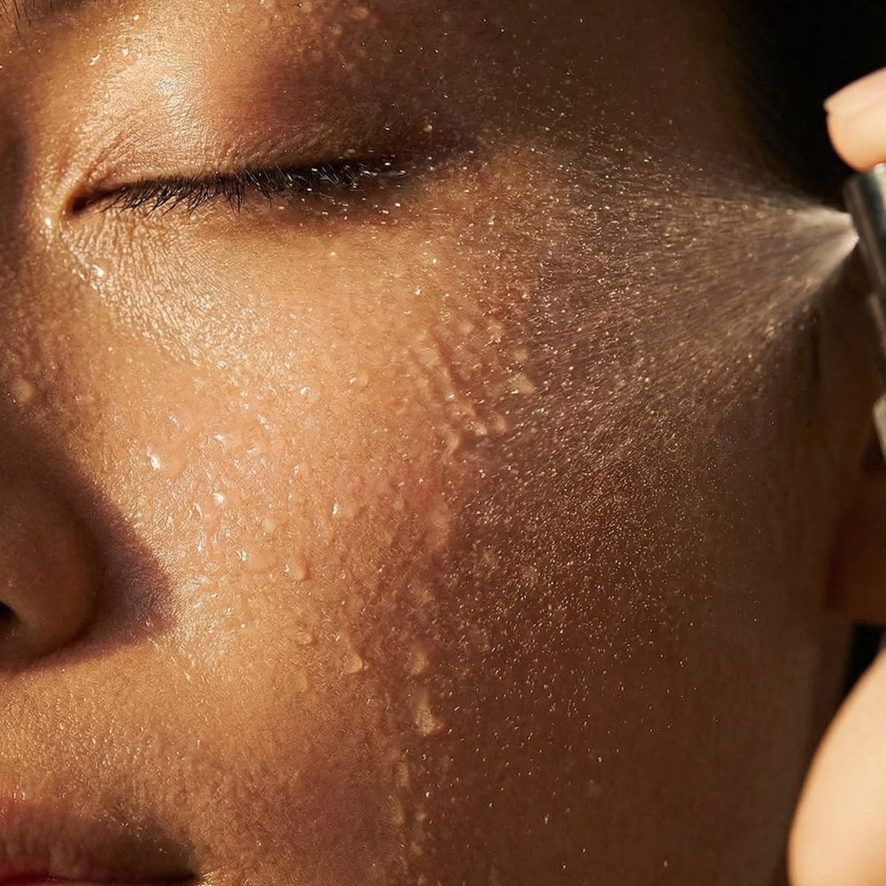 Le Prunier Plum Spritz (60 ml) - product shown being applied to model's face.