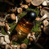 Heretic Parfum Haxan Eau de Macabre (30 ml) - product shown surrounded by mushrooms.