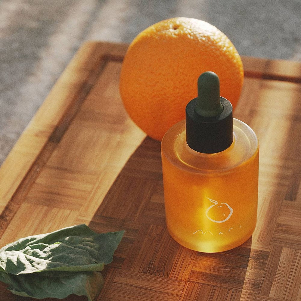 Mari Ostara All-Over Oil (50 ml) - product shown on wooden board with orange.
