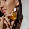 14th Night The Hair Elixir (30 ml) - product shown being held by model.
