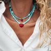 Close u of model wearing Goupi Turquoise Bead Necklace in Big Heart and Small Heart shown layered (each sold separately)