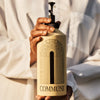 A person in a white shirt holds Commune Seymour Body Wash & Reusable Pump (750 ml)