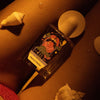 Lifestyle shot of Maison Matine Bain De Minuit Eau de Parfum (100 ml) bottle surrounded by seashells.