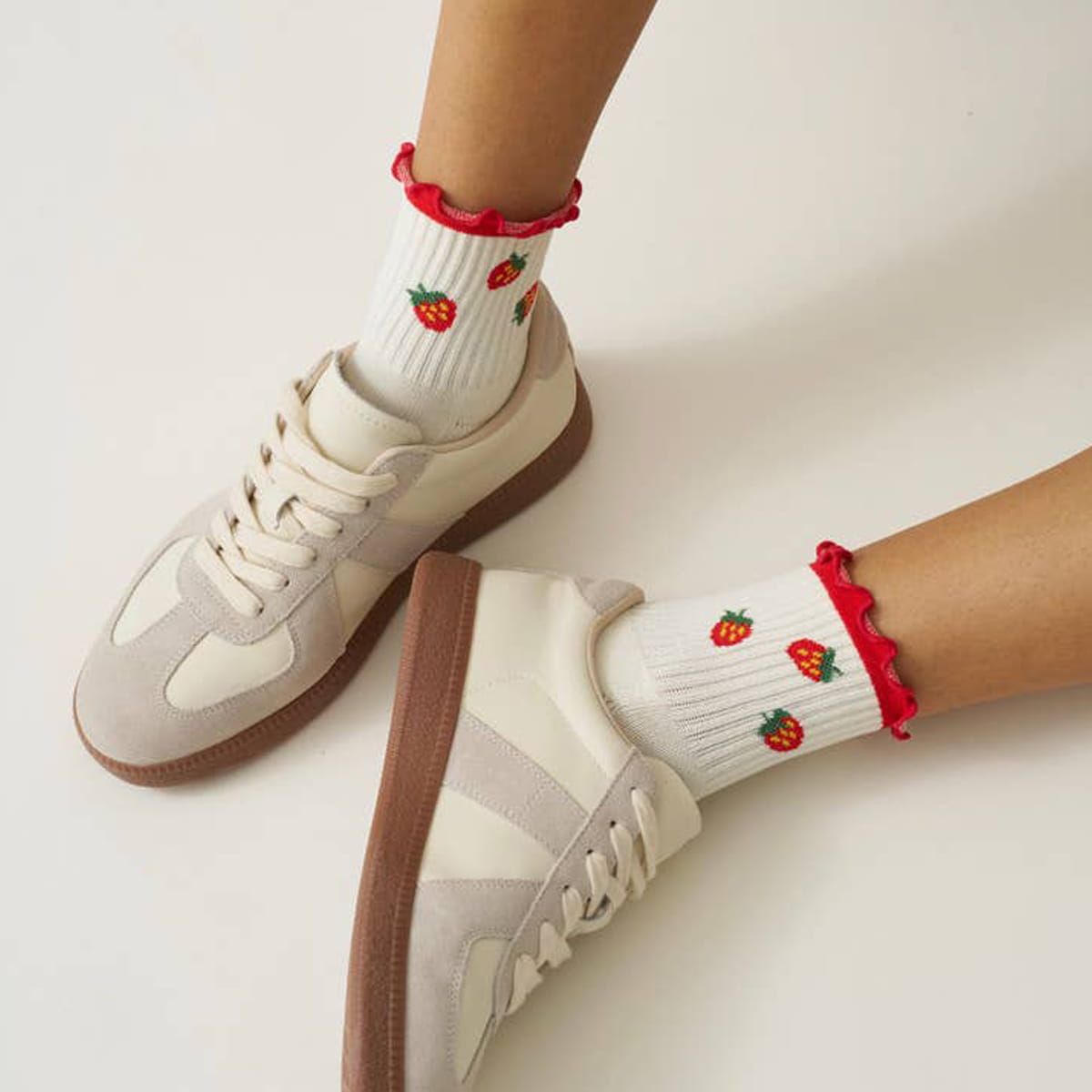 Model wearing Effortless Club Strawberry Ruffle Grip Socks (1 pair) with sneakers