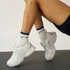 Model wearing Effortless Club Good Energy Grip Socks (1 pair) with athletic shoes