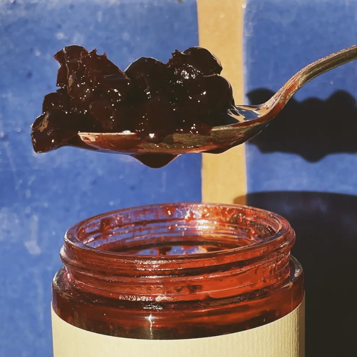 C. Cassis Salted Currant Compote jar open with compote on spoon