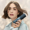 Model with short hair holding Roz Milk Styling Mousse (150 ml)