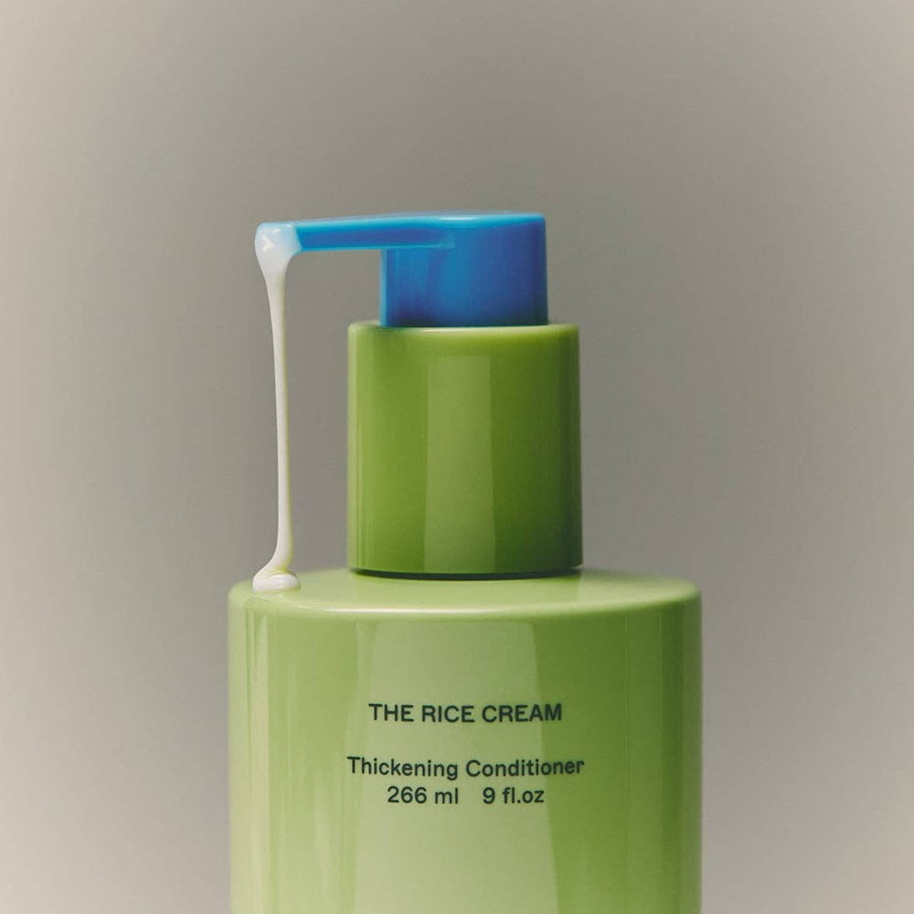 Close up of BASE-K The Rice Cream Thickening Conditioner (266 ml), showing conditioner dripping from the nozzle