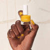 Cote Nail Polish - Songbird (8 ml) - product shown being held by model's hand.