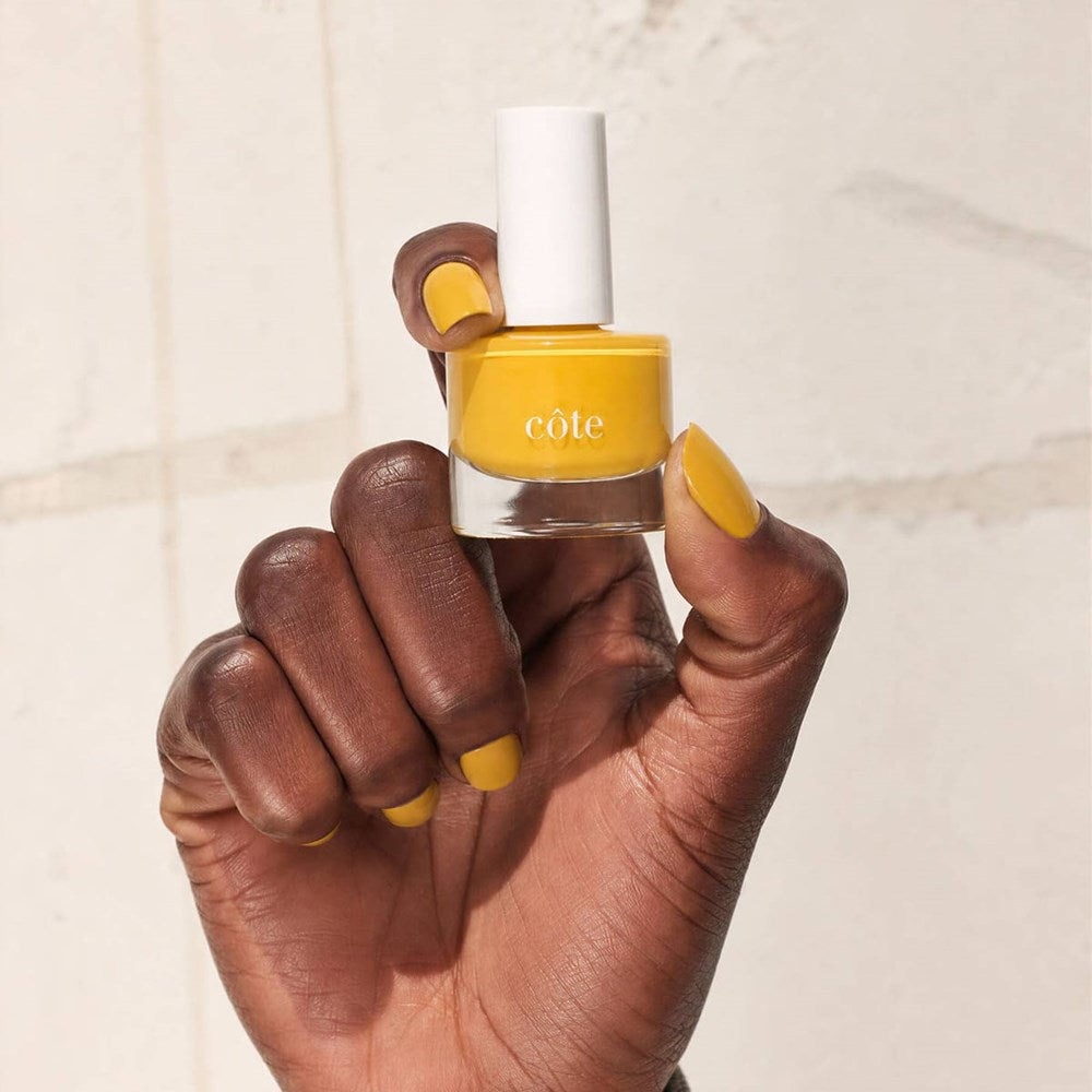 Cote Nail Polish - Songbird (8 ml) - product shown being held by model's hand.