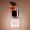 Essential Parfums Ambre Latte by Jordi Fernandez (100 ml Refillable) - product shown with amber and date on lid.