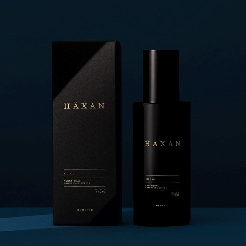 Heretic Parfum Haxan Body Oil (150 ml) - product shown on blue background. 