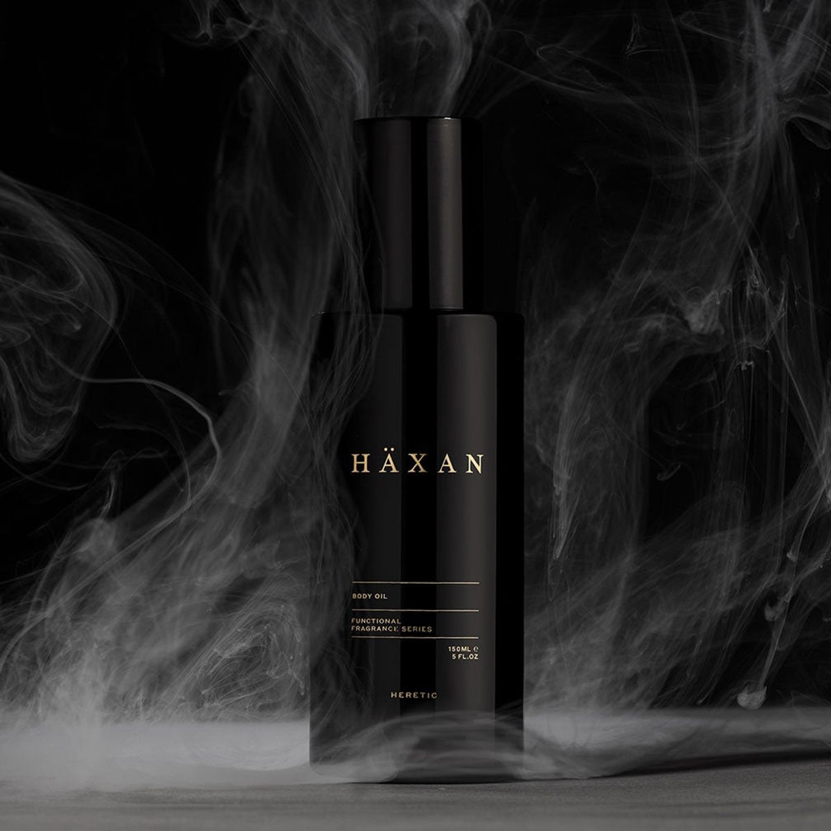 Heretic Parfum Haxan Body Oil (150 ml) - product shown surrounded by smoke on black background