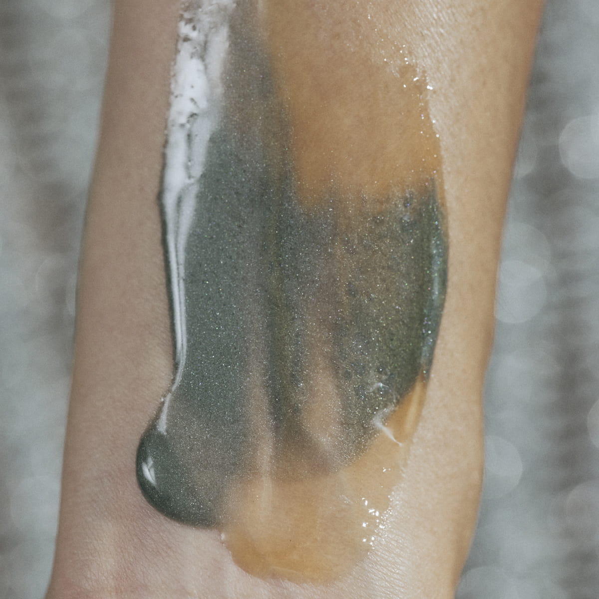 A close-up of Activist Manuka Honey Glacial Clay Mask product swatch applied to skin
