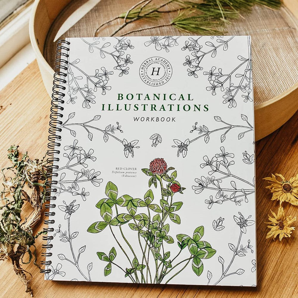 Herbal Academy Botanical Illustrations Workbook (1 pc) - product shown on wooden counters.