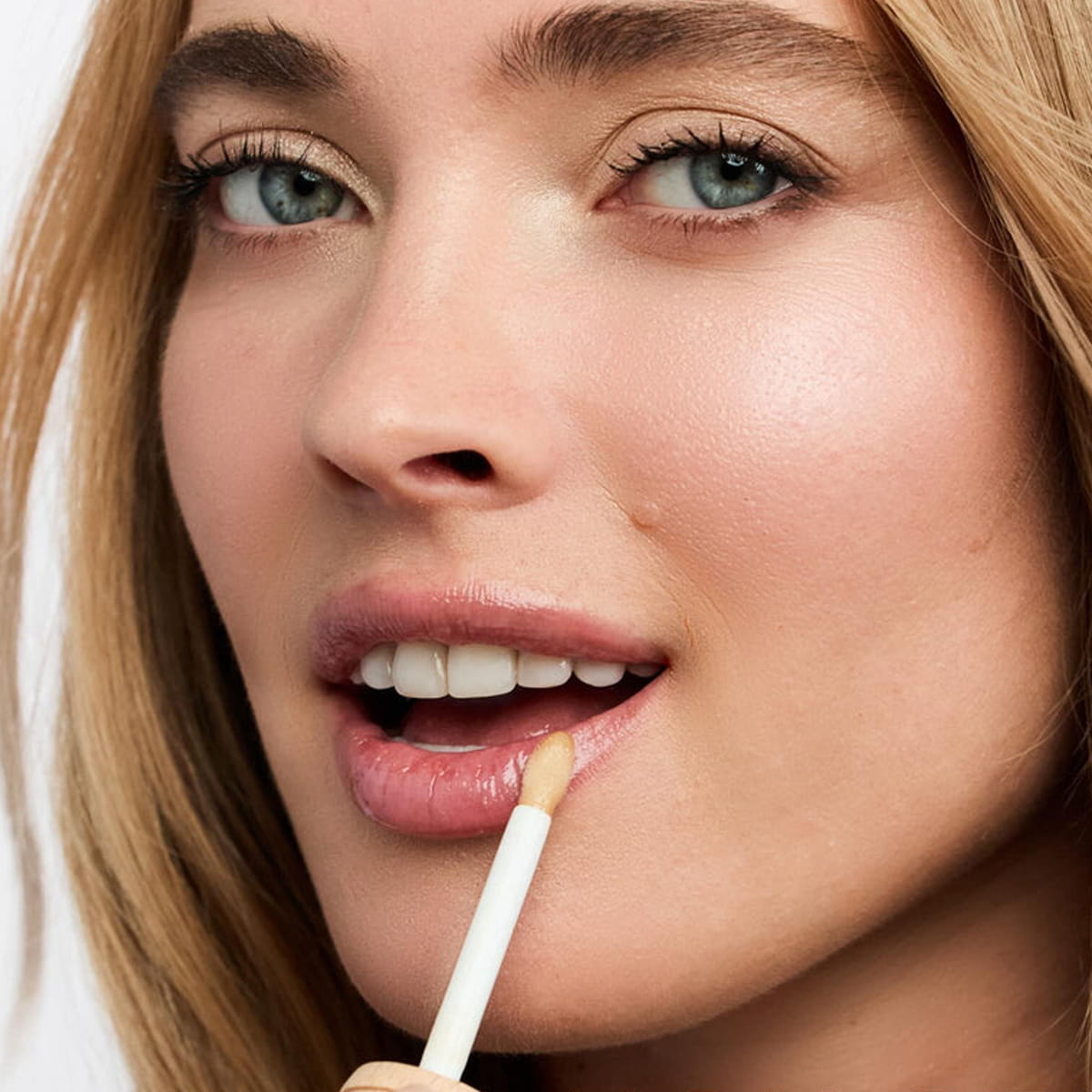 Nuxe Reve de Miel Gold Honey Lip Care (10 ml) - product shown being applied on lips. 