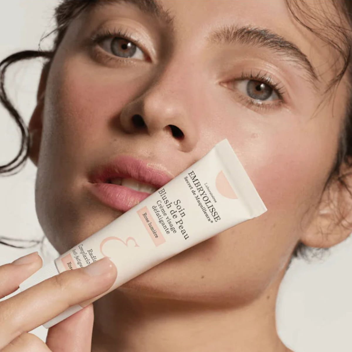 Embryolisse Radiant Complexion Cream - Rose Glow (30 ml) - product shown held by model.