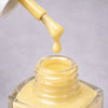 Kure Bazaar Nail Lacquer - Yellow Butter (10 ml) - product shown with lid removed.