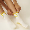 Effortless Club Lemon Ruffle Grip Sock (1 pair) - product shown being put on model's foot.
