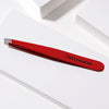 Tweezerman Slant Tweezer - Signature Red (1 pc) - product lifestyle shot shown.